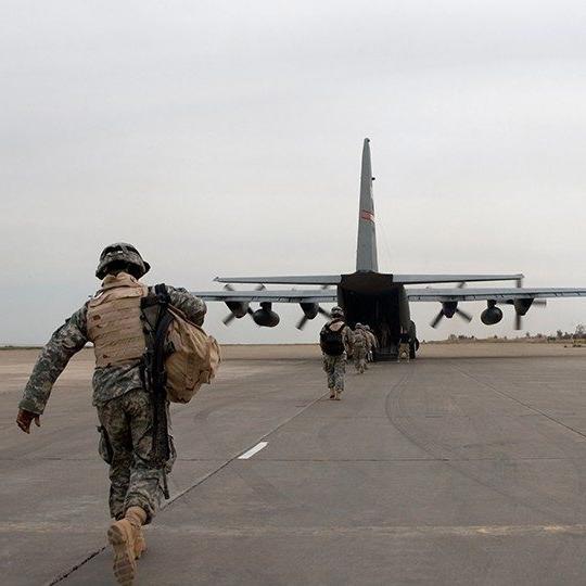 作战人员将装备装载到配备机载技术的C-17飞机的后部
